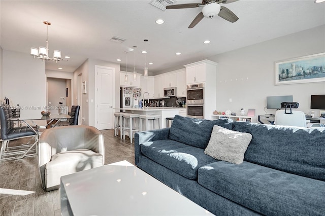 living room with visible vents, recessed lighting, and light wood-type flooring