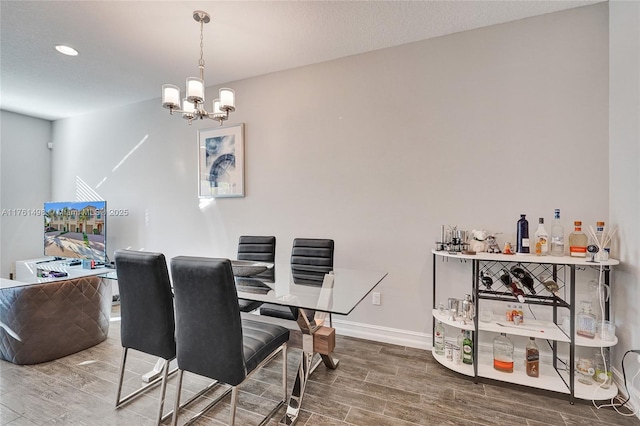 dining room featuring a notable chandelier, baseboards, and wood finish floors