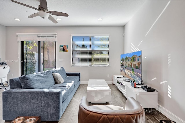 living area featuring ceiling fan, a healthy amount of sunlight, and wood tiled floor