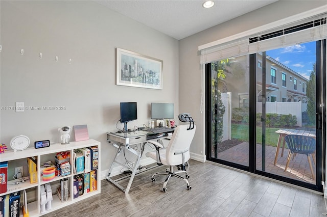 home office featuring baseboards, a textured ceiling, and wood finished floors