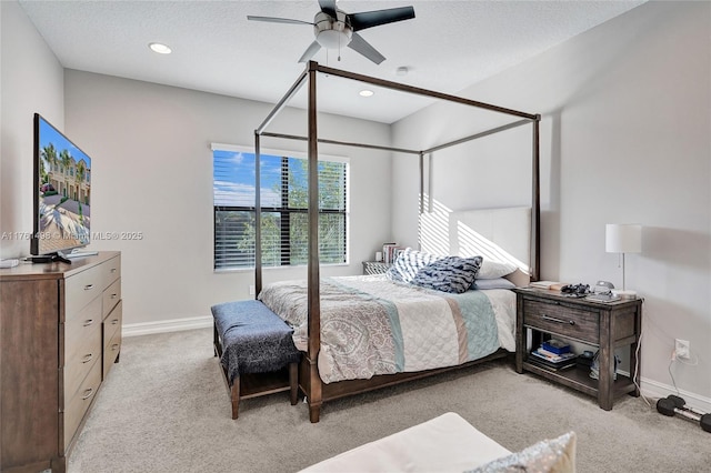 bedroom with a textured ceiling, ceiling fan, baseboards, and light carpet