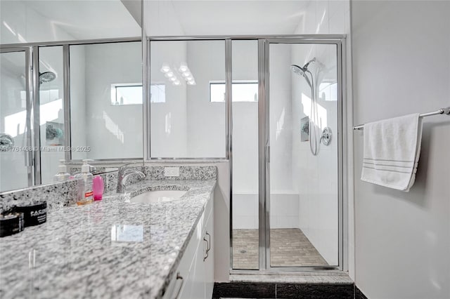 full bath with a stall shower and vanity