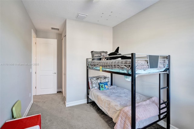 carpeted bedroom featuring visible vents and baseboards