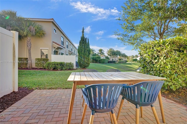 view of patio with outdoor dining space and fence