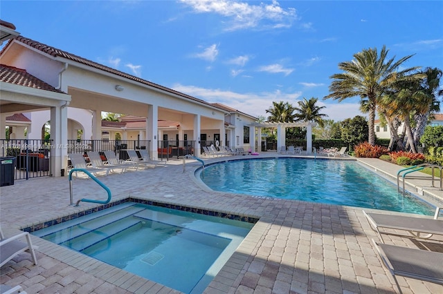 pool with a patio, fence, a pergola, and a hot tub