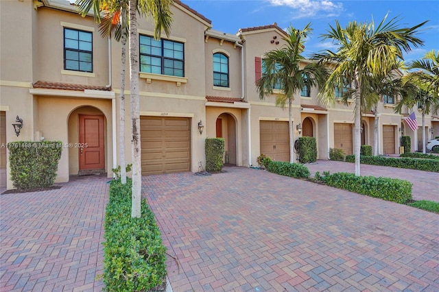 view of front of property featuring a tiled roof, driveway, and stucco siding