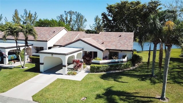 rear view of property with concrete driveway, a yard, and stucco siding