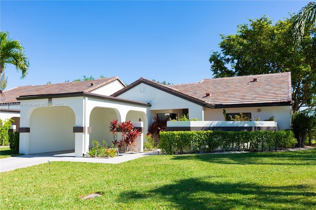 view of front of house with a carport, a tile roof, stucco siding, and a front lawn