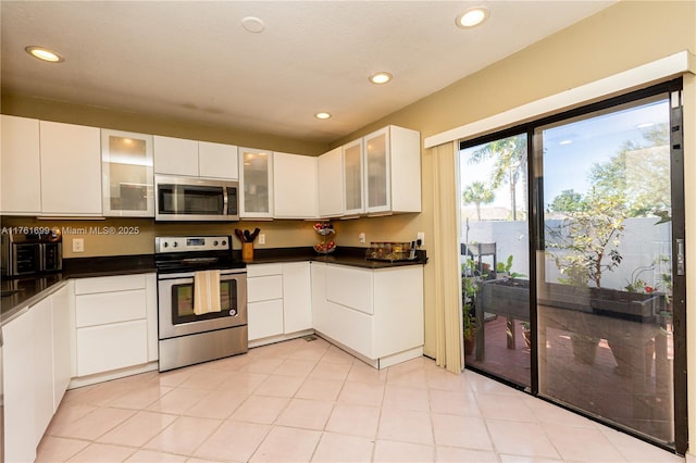 kitchen with dark countertops, recessed lighting, white cabinets, and stainless steel appliances