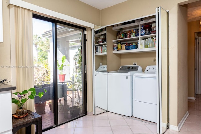 clothes washing area featuring light tile patterned flooring and washing machine and clothes dryer