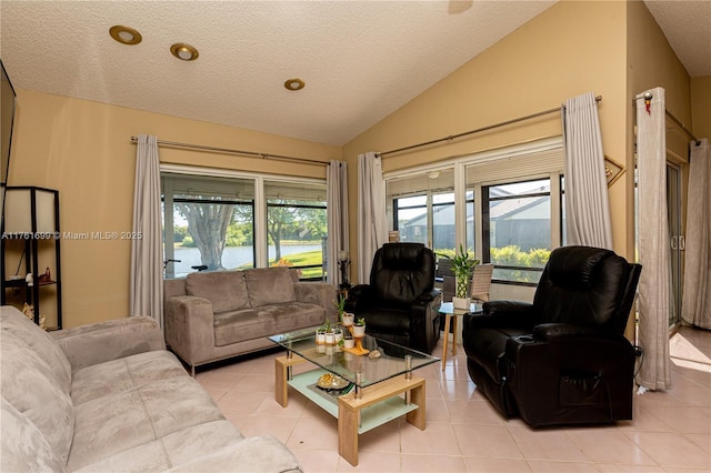 living area featuring a textured ceiling, light tile patterned flooring, and vaulted ceiling