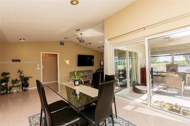 dining area with visible vents, a ceiling fan, light tile patterned flooring, and lofted ceiling
