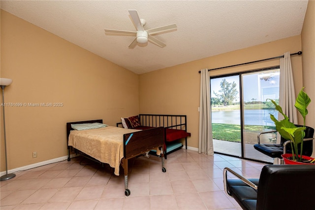 bedroom featuring a water view, access to outside, a textured ceiling, light tile patterned flooring, and lofted ceiling