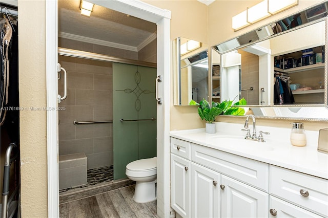 bathroom featuring toilet, ornamental molding, a stall shower, and wood finished floors