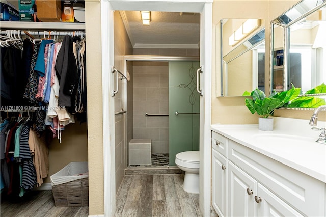 full bathroom with crown molding, toilet, a shower stall, and wood finished floors