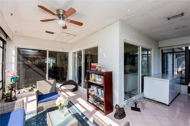 sunroom / solarium featuring visible vents, ceiling fan, and outdoor lounge area