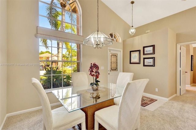 dining area featuring baseboards, carpet, a chandelier, and high vaulted ceiling