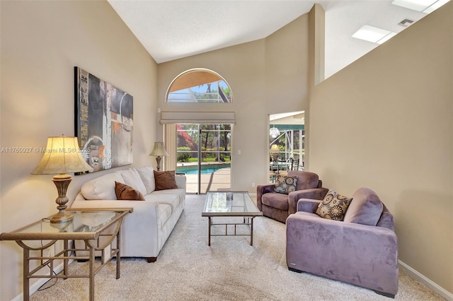 carpeted living area featuring visible vents, baseboards, and a towering ceiling