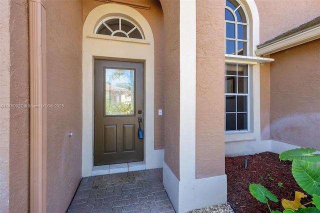 doorway to property featuring stucco siding