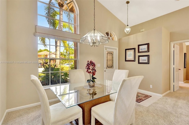dining area with high vaulted ceiling, baseboards, an inviting chandelier, and carpet floors