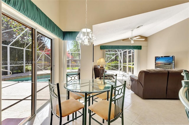 dining space featuring lofted ceiling, ceiling fan with notable chandelier, light tile patterned flooring, and a sunroom