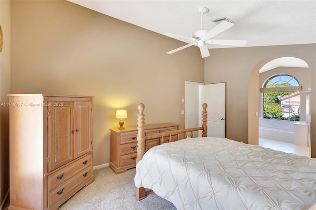 bedroom with visible vents, baseboards, light carpet, arched walkways, and high vaulted ceiling