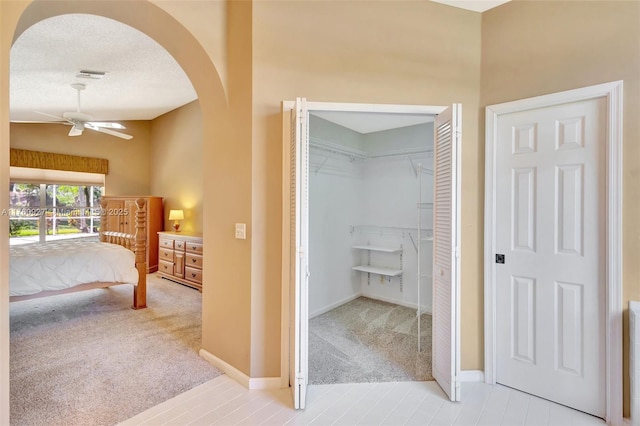 interior space with visible vents, baseboards, carpet flooring, arched walkways, and a textured ceiling