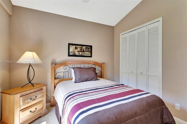 carpeted bedroom featuring vaulted ceiling and a closet