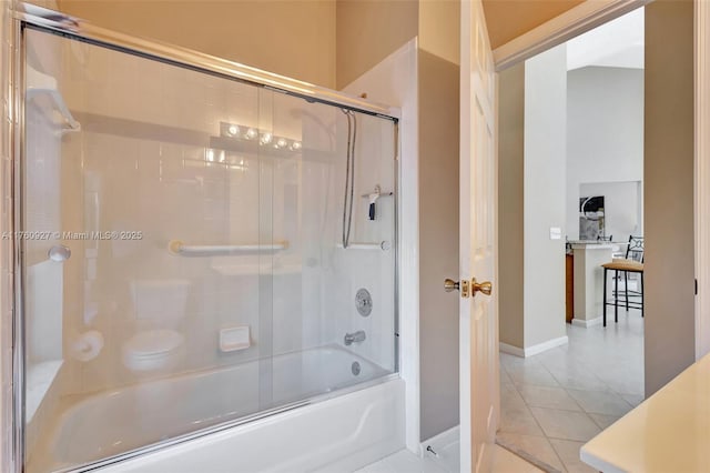 bathroom featuring combined bath / shower with glass door, baseboards, and tile patterned floors