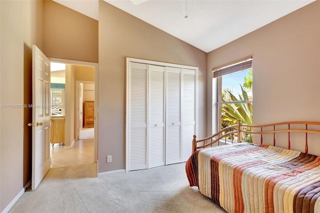 bedroom with baseboards, a closet, light carpet, and lofted ceiling