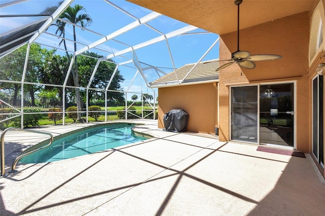 pool featuring glass enclosure, ceiling fan, and a patio area