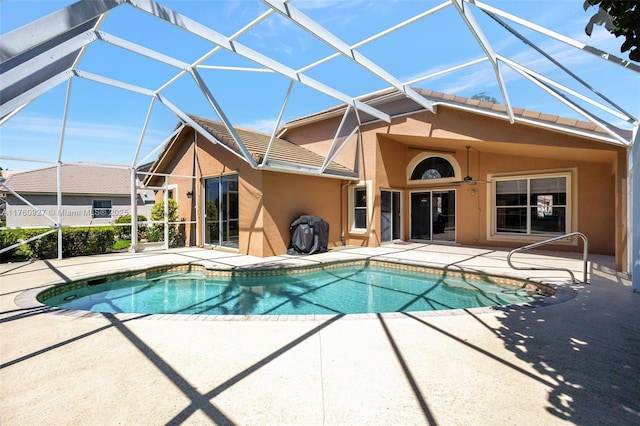 outdoor pool with glass enclosure and a patio area