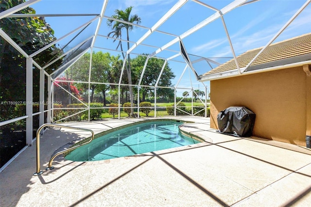 outdoor pool featuring glass enclosure and a patio