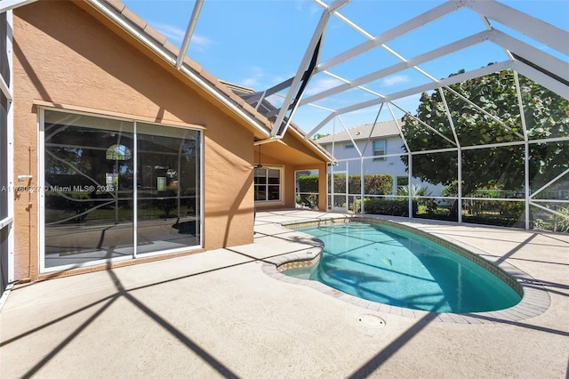 outdoor pool with glass enclosure and a patio area