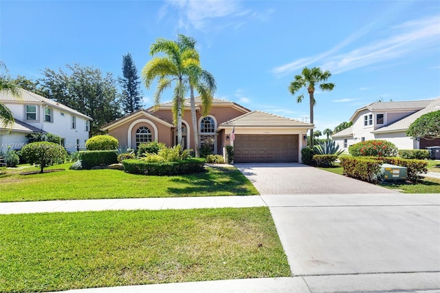 view of front of property with a front yard, decorative driveway, a garage, and stucco siding