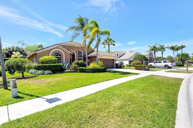 mediterranean / spanish-style house with concrete driveway, an attached garage, a front yard, and stucco siding