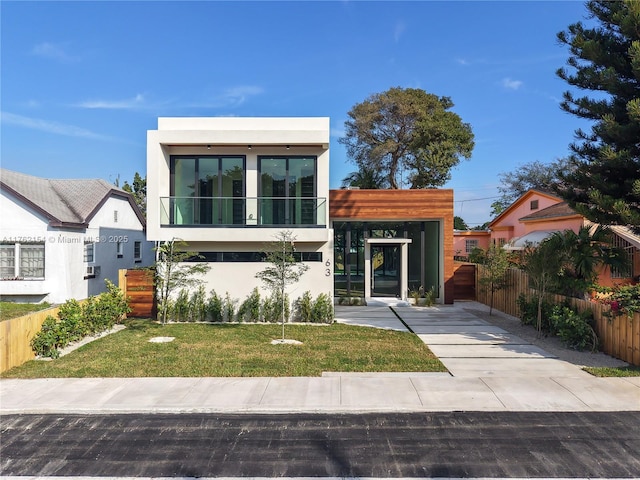 contemporary home featuring a front yard and fence