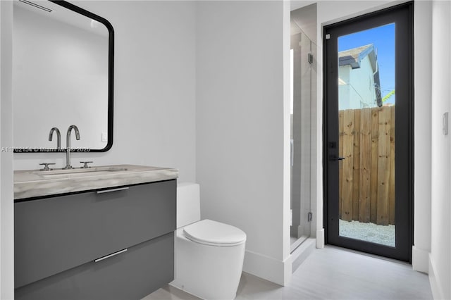 bathroom featuring vanity, toilet, and a shower stall