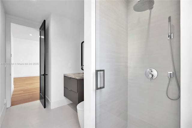 full bathroom with baseboards, toilet, a stall shower, and vanity