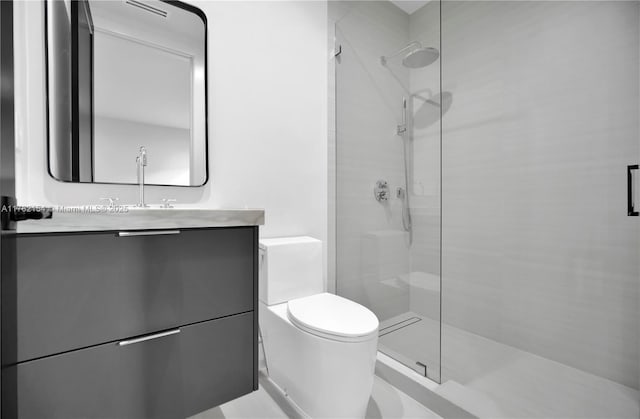 bathroom with toilet, vanity, and a tile shower