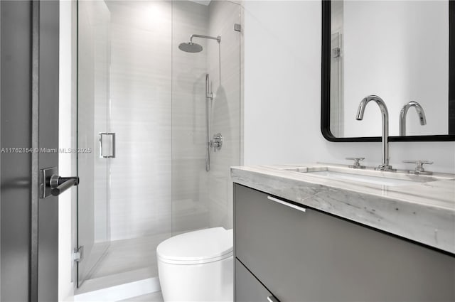 bathroom with vanity, toilet, and a stall shower