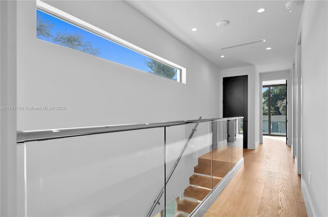 stairs with recessed lighting, a healthy amount of sunlight, baseboards, and wood finished floors
