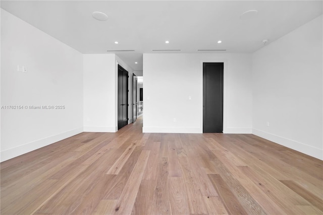 empty room with light wood-style flooring, recessed lighting, and baseboards