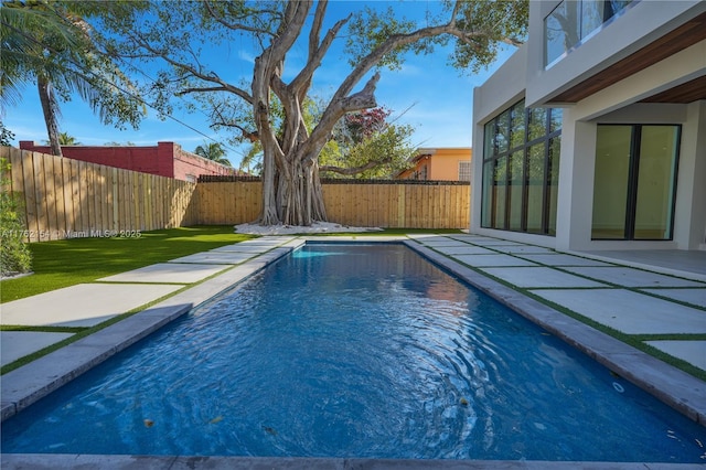 view of pool featuring a fenced in pool, a fenced backyard, and a patio area