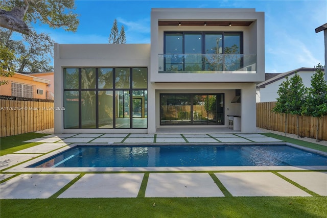 back of property featuring stucco siding, fence private yard, and a patio