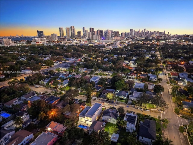 aerial view at dusk featuring a city view
