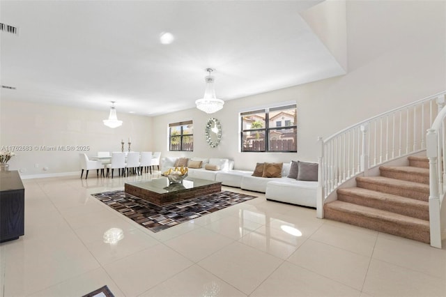 living area with tile patterned floors, stairway, baseboards, and visible vents