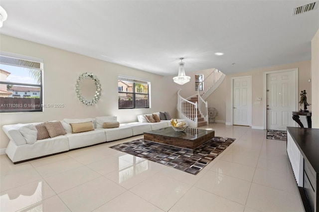 living room featuring tile patterned floors, visible vents, plenty of natural light, and stairway