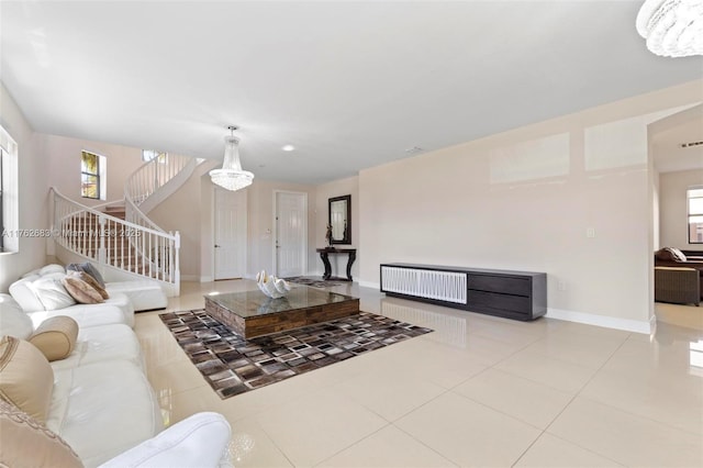 living area with tile patterned floors, stairway, baseboards, and a wealth of natural light