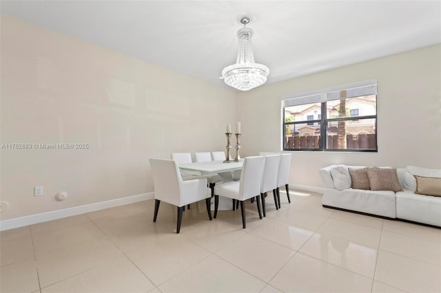 dining space featuring baseboards, a notable chandelier, and light tile patterned flooring